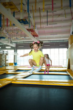 güzel küçük kız oyun bir kulüpte bir trambolin üzerinde atlama