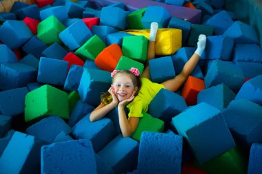 yumuşak renkli küpler bir oyun odasında yatan güzel küçük kız