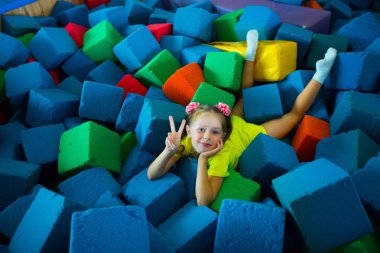 yumuşak renkli küpler bir oyun odasında yatan güzel küçük kız