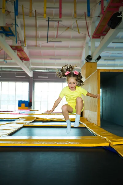 güzel küçük kız oyun bir kulüpte bir trambolin üzerinde atlama