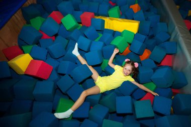 güzel küçük neşeli kız yumuşak oyuncaklar küpleri lunaparktaki yalan