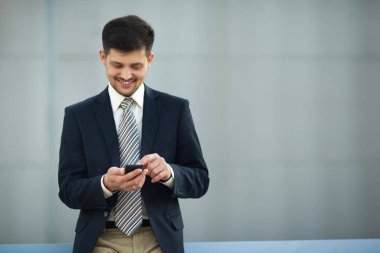 yakışıklı genç adam onun elinde bir telefon ile sokakta yaz aylarında arıyor takım elbiseli