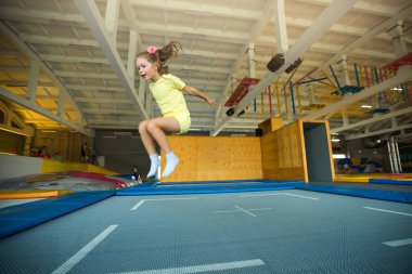 güzel küçük kız eğlence merkezi bir trambolin üzerinde atlama