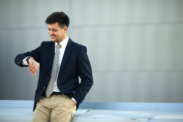 handsome young man in a suit looking at the clock