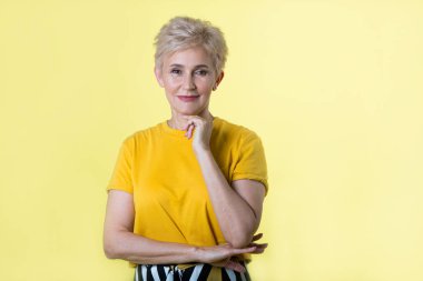şık yaşlı kadın ile sarı bir arka plan üzerinde bir kısa saç modeli