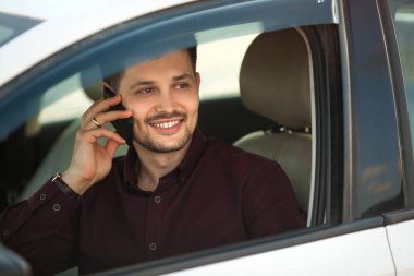 arabada oturan ve telefonda konuşurken bir gömlek güzel genç adam