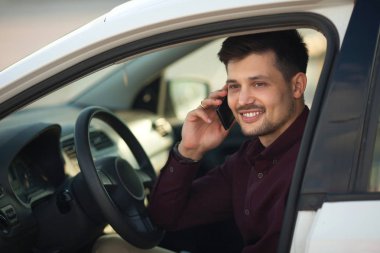 arabada oturan ve telefonda konuşurken bir gömlek güzel genç adam