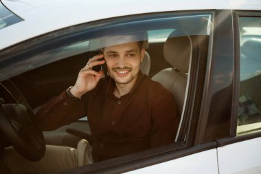 arabada oturan ve telefonda konuşurken bir gömlek güzel genç adam