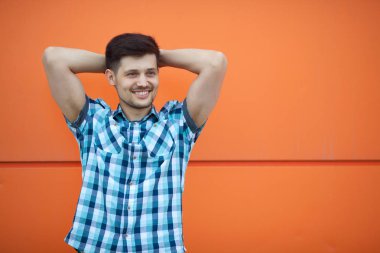 turuncu bir arka plan üzerinde bir gömlekli yakışıklı genç adam