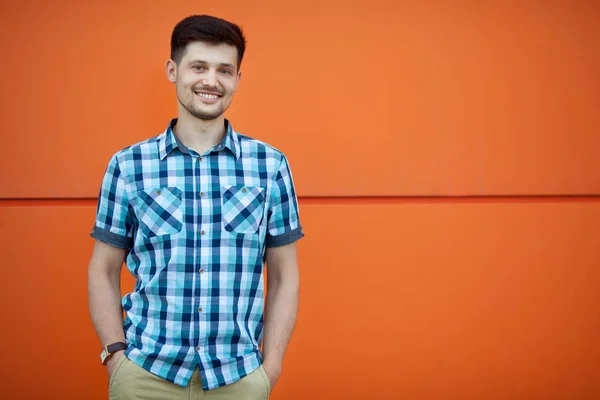 handsome young guy in a shirt on an orange background