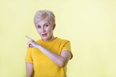 parmağıyla işaret sarı bir arka plan üzerinde kısa bir saç modeli ile güzel şık kadın