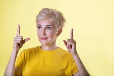 bir hareketi el ile sarı bir arka plan üzerinde kısa bir saç modeli ile güzel şık kadın