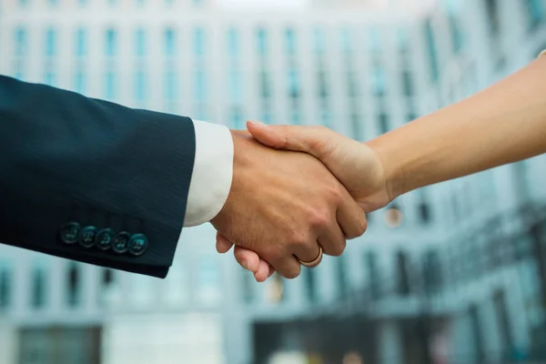 handshake of a man and a girl on a building background