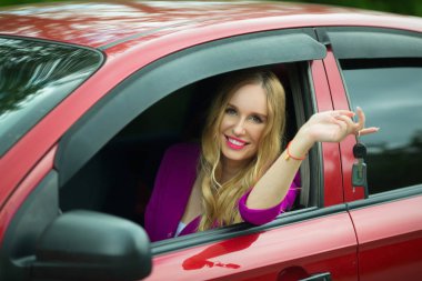 güzel genç kız saçını bir arabada oturan tuşları ile el ile