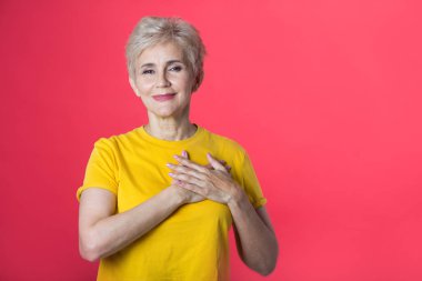 kırmızı bir arka plan üzerinde sarı bir tişört kısa bir saç kesimi ile yaşta şık kadın