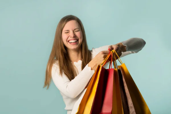 Bela Jovem Segurando Sacos Compras Fundo Azul Com Expressões Faciais — Fotografia de Stock