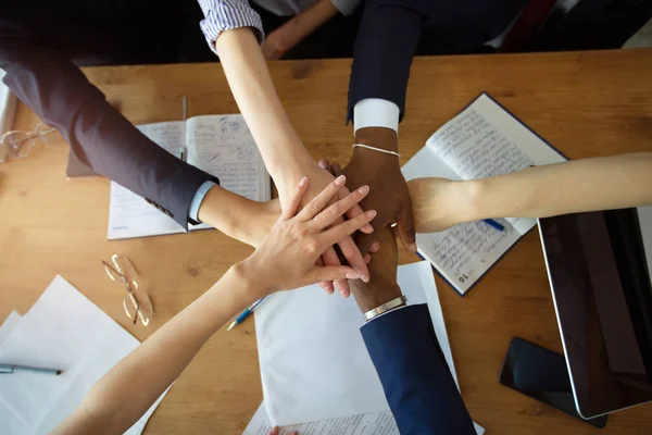 team of young business people hold hands at office at work