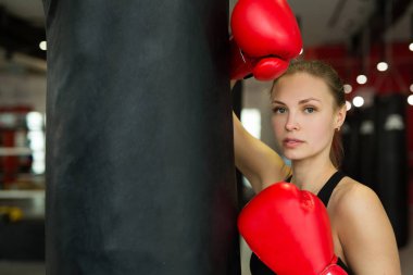 güzel genç kız yakınındaki kum torbası eğitim spor salonunda boks eldiven