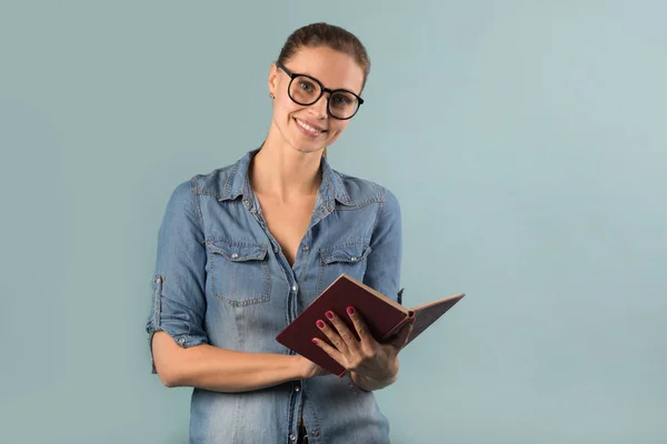 Gyönyörű Fiatal Lány Szemüveges Olvasson Egy Könyvet Kék Háttér — Stock Fotó