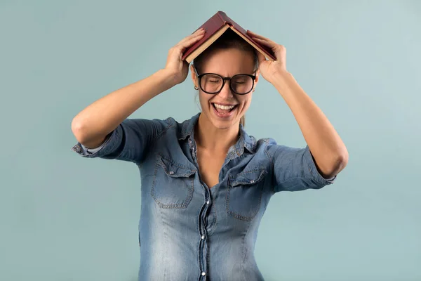 Bela Menina Óculos Segurando Livro Sobre Sua Cabeça Com Expressões — Fotografia de Stock