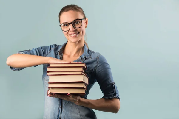Bela Jovem Com Óculos Segurando Livros Suas Mãos Contra Fundo — Fotografia de Stock