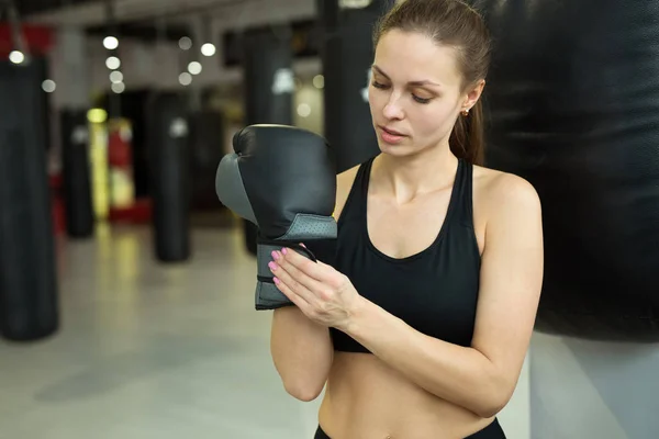 Hermosa Joven Pie Cerca Del Saco Boxeo Gimnasio Poniéndose Guantes —  Fotos de Stock