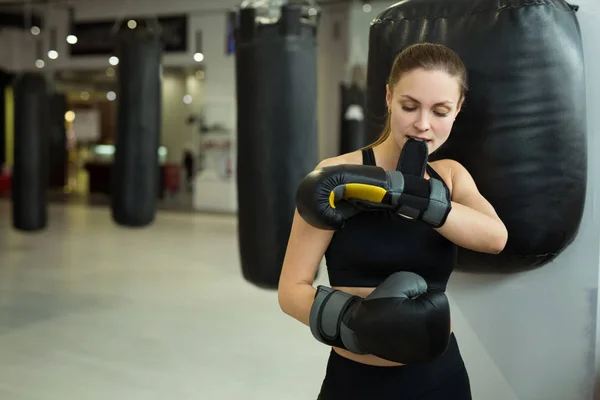 Hermosa Joven Pie Cerca Del Saco Boxeo Gimnasio Poniéndose Guantes —  Fotos de Stock