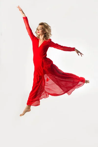 Hermosa Joven Vestido Rojo Saltando Una Pose Ballet Sobre Fondo —  Fotos de Stock