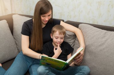 güzel genç aile anne ve oğlu evde bir kitap okumak