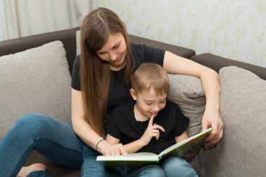 güzel genç aile anne ve oğlu evde bir kitap okumak