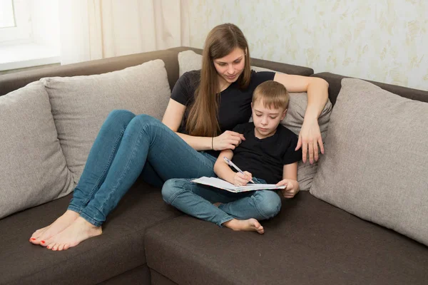 beautiful young family mother and son do homework lessons