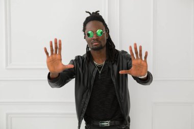 Beyaz arka plan üzerinde el hareketi ile siyah ceketli şık Afrikalı adamı