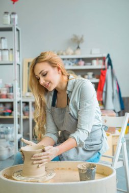 akan ile güzel genç kız saç mı bir çömlek atölyesinde kendi elleriyle bir kil sürahi