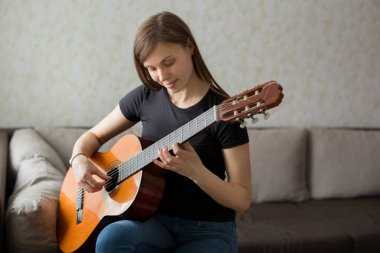 güzel genç kız evde gitar çalıyor
