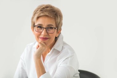 gözlük ve beyaz zemin üzerine kısa saç kesimi ile şık yaşlı kadın portresi