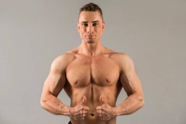 gri arka planda kaslar ile yakışıklı adam