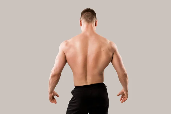 英俊的男人与肌肉在灰色背景与肌肉 — 图库照片