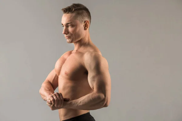 Guapo Atleta Masculino Con Músculos Bombeados Sobre Fondo Gris — Foto de Stock