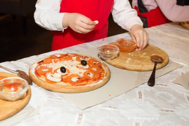 Kırmızı önlük kızlar bir restoranda pizza pişirmek