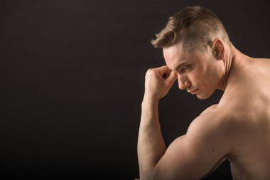 siyah bir arka planda kaslarla yakışıklı adam geri oturma