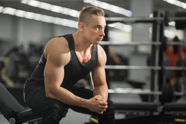 spor salonunda kasları ile iyi durumda yakışıklı adam