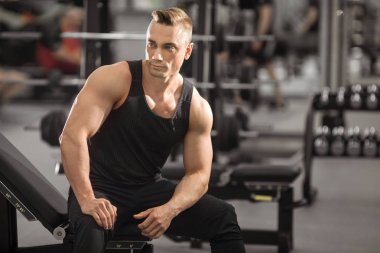 spor salonunda kasları ile iyi durumda yakışıklı adam