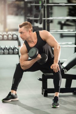 Dambıl ile egzersizler egzersiz jimnastik kaslarıyla iyi durumda yakışıklı adam