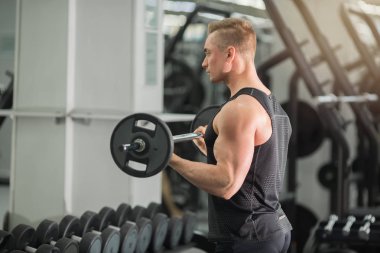 Halter ile spor salonu eğitimi kaslar ile iyi fiziksel durumda yakışıklı adam