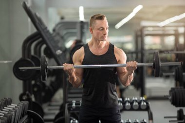 Halter ile spor salonu eğitimi kaslar ile iyi fiziksel durumda yakışıklı adam