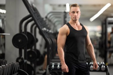 spor salonunda kasları ile iyi durumda yakışıklı adam