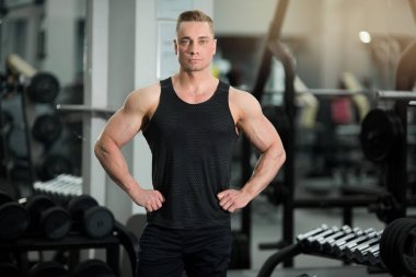 spor salonunda kasları ile iyi durumda yakışıklı adam