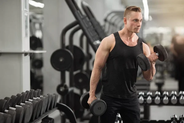 Dambıl ile egzersizler egzersiz jimnastik kaslarıyla iyi durumda yakışıklı adam