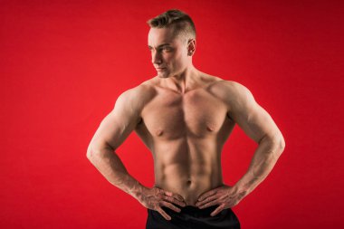 kırmızı arka plan üzerinde atletik üniformalı yakışıklı genç adam