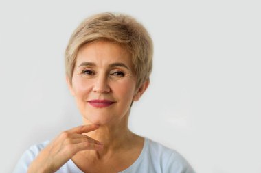 beyaz bir arka plan üzerinde kısa saç kesimi ile şık güzel yaşlı kadın